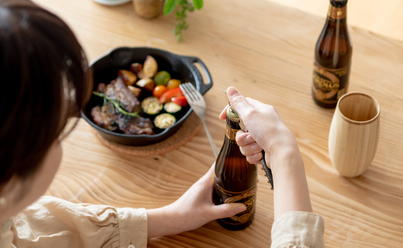 女性がビール瓶の栓を開けようとしている様子